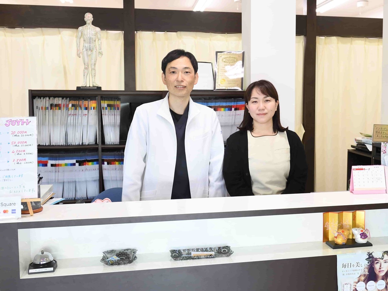 「姫路市の鍼灸整骨院一心堂の院内受付風景。交通事故後のむち打ちや腰痛、手足のしびれなどの施術に対応する院長とスタッフ。」