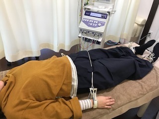 微弱電流機器を使用しながら、全身状態や自律神経の影響を確認している施術の様子。姫路市の鍼灸整骨院一心堂で、腰痛に対して全身を確認しながら施術を行っているイメージ。