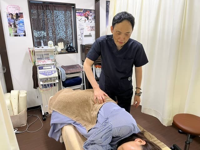 推定した関節の機能異常への施術後に、施術前にみられた筋スパズムの変化を確認している様子