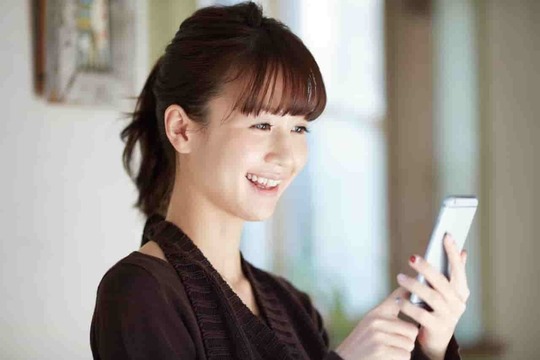 スマートフォンで予約や問い合わせを行う女性の写真。姫路市の鍼灸整骨院一心堂では、電話・LINE・WEBから簡単に予約できます。