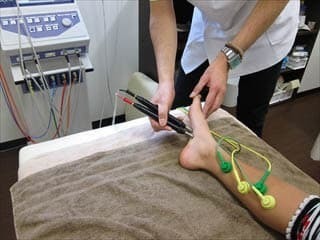 微弱電流治療器ソーマダインを用いて、施術部位の状態を確認しながら対応している様子