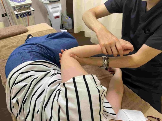 「肩の可動域が戻り始める時期に、動きの質を確認しながら行う施術イメージ」