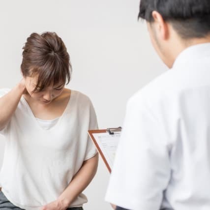 交通事故後の痛みについて、施術前に状態を確認している様子