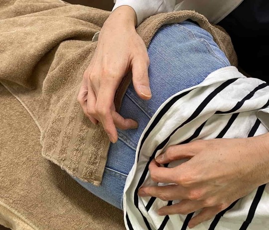 「姫路市の鍼灸整骨院一心堂で行うSCJM法（関節運動学に基づいた施術）の様子。関節の奥にあるわずかな引っかかりに手技でアプローチし、腰痛・坐骨神経痛・膝の痛みなど慢性的な症状改善を目指す場面。」