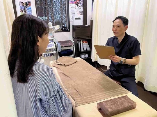 「姫路市の鍼灸整骨院一心堂で、院長が患者さまに丁寧にカウンセリングを行っている様子」